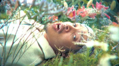 a man laying in the grass with his eyes closed