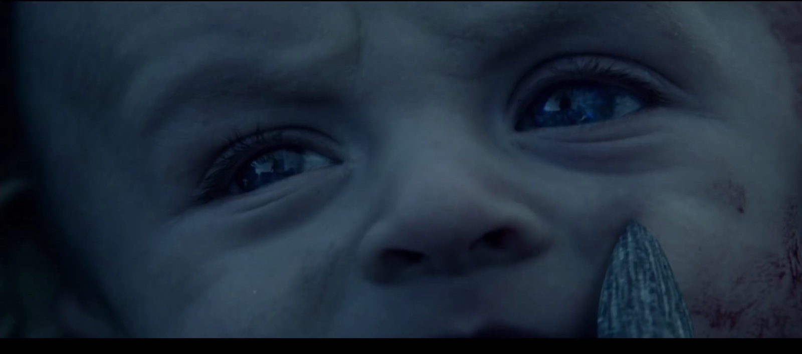 a close up of a child with a knife in his mouth