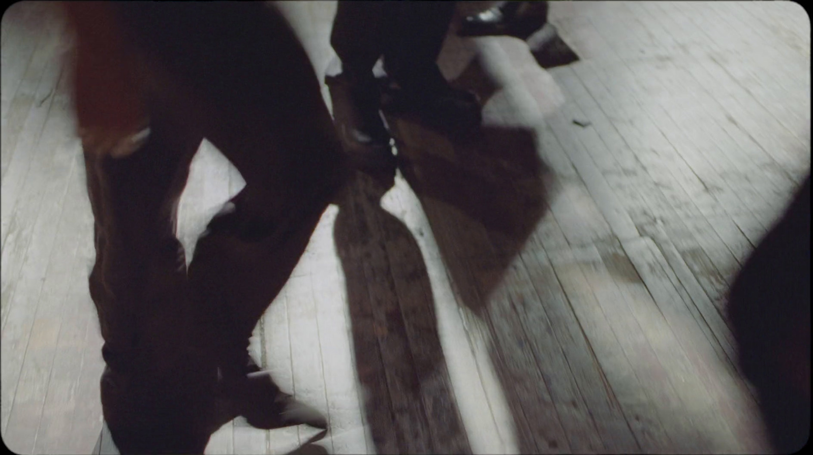 a couple of people standing on top of a wooden floor