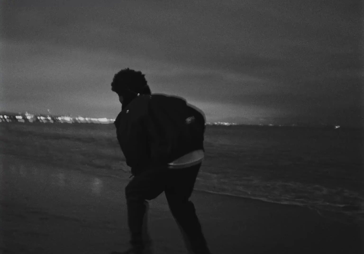 a man standing on top of a beach next to the ocean