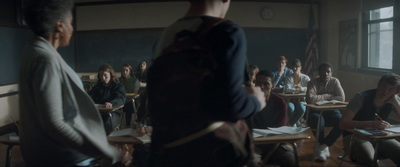 a group of people sitting at desks in a classroom