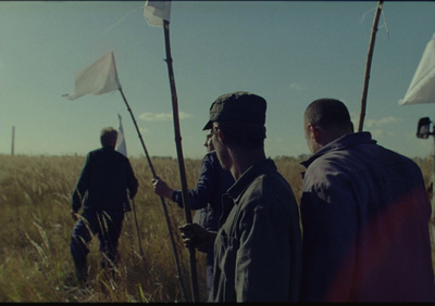 a group of men standing next to each other in a field