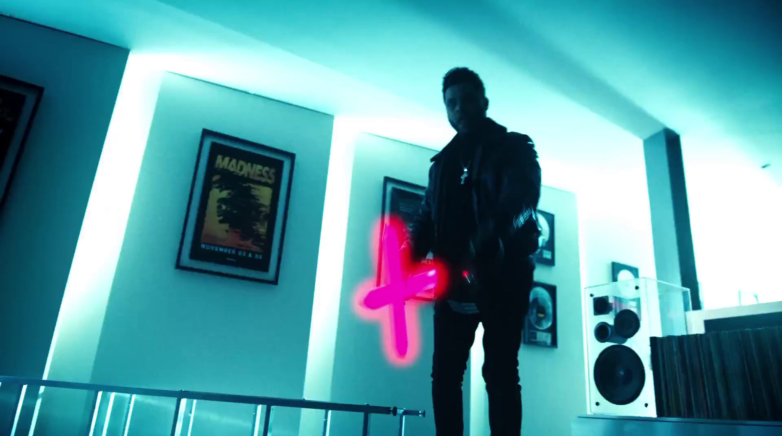 a man standing in a room holding a neon pink object