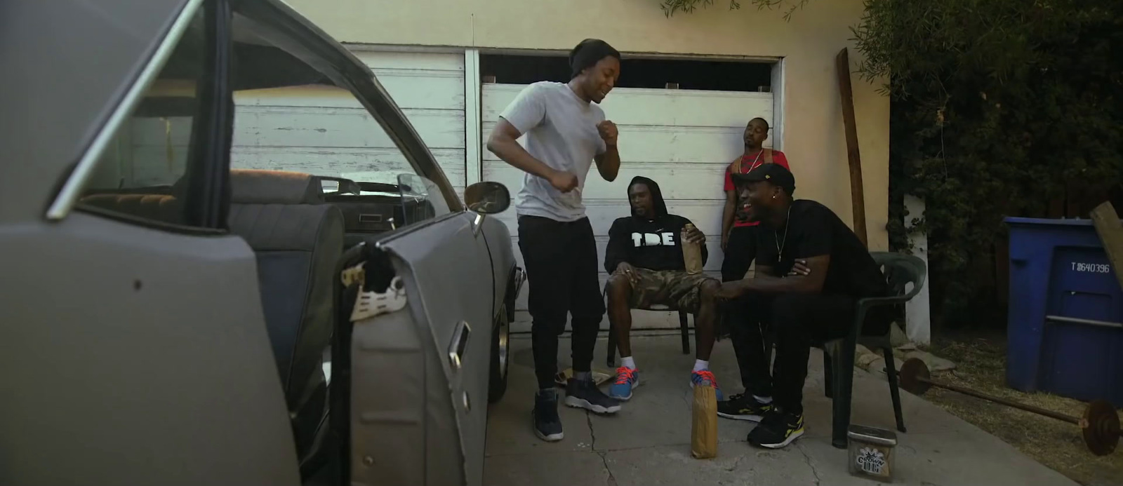 a group of young men standing next to a car