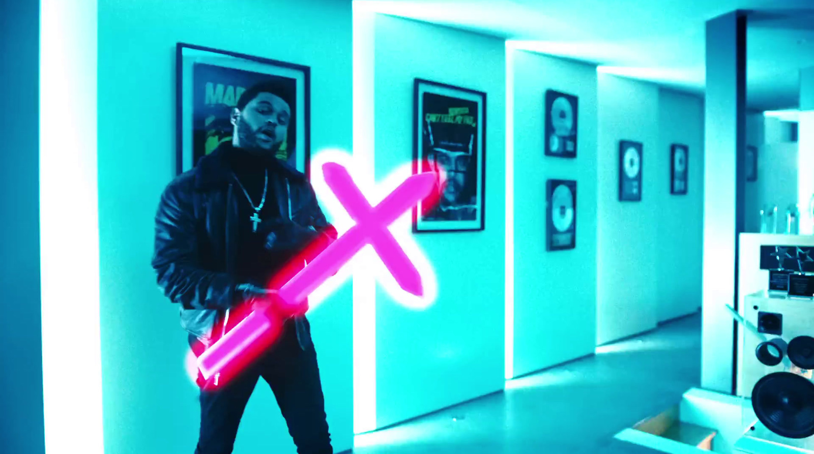 a man standing in a room holding a neon pink light saber