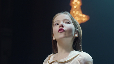 a young girl in a white dress looking up