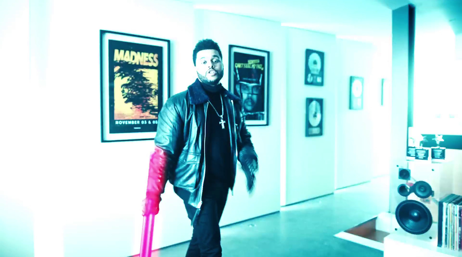 a man walking down a hallway holding a pink umbrella