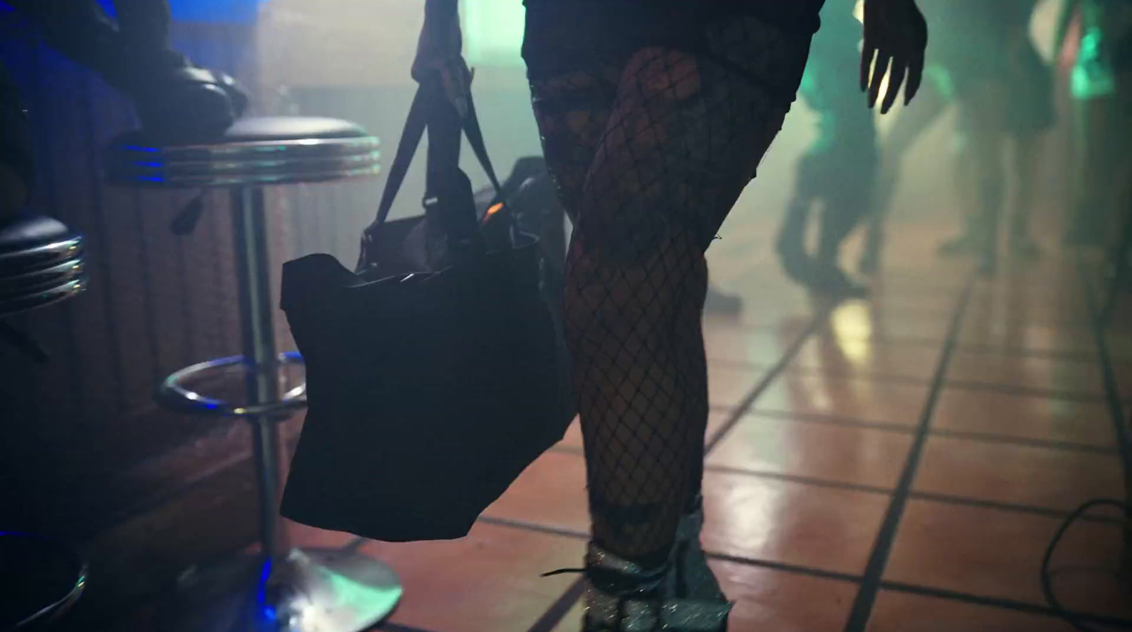 a woman in fishnet stockings holding a purse