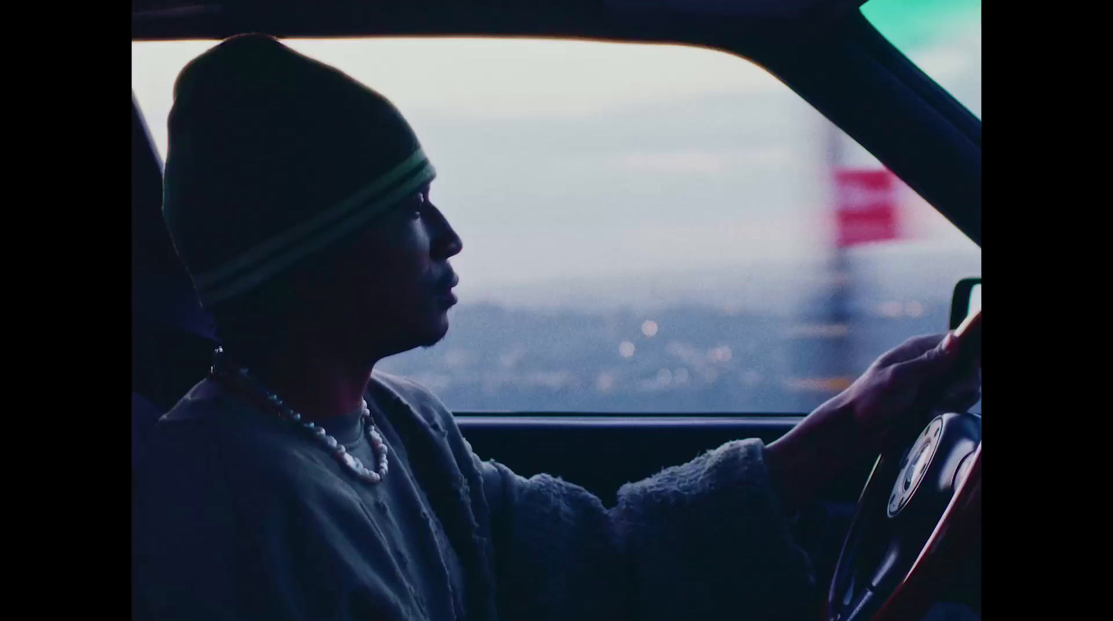 a man driving a car with a view of a city