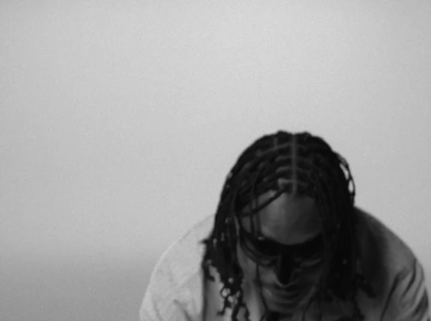 a man with dreadlocks sitting on a bed