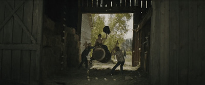 a group of people standing around a barn