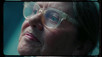 a woman wearing glasses looking up at something