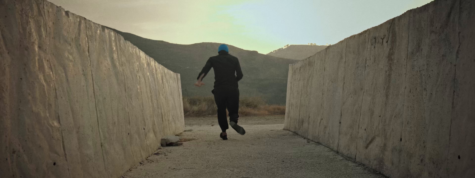 a man in a wet suit is running down a path