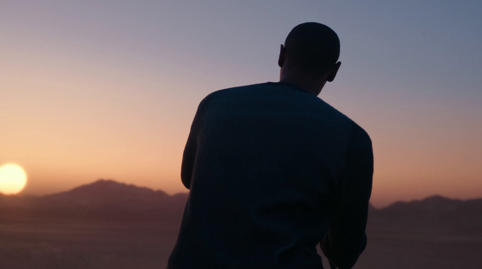 a man standing in front of a sunset