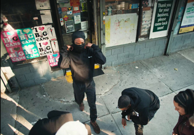 a group of people standing on a sidewalk next to a building