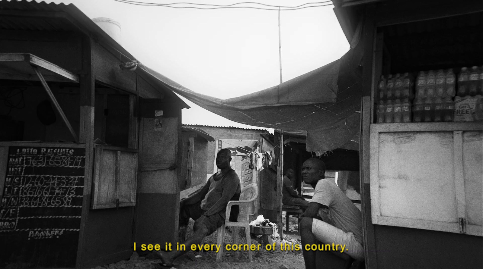 a black and white photo of two people in a shack