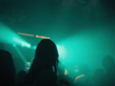 a woman standing in front of a crowd at a concert