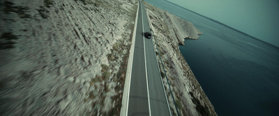 a car driving down a road next to a cliff