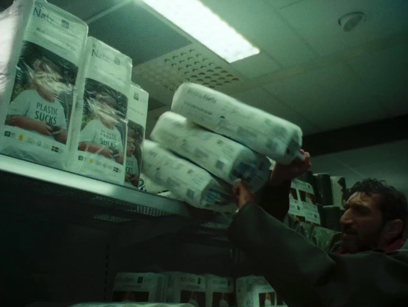 a man holding a stack of newspapers in a store