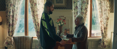 a man standing next to a woman in front of a window