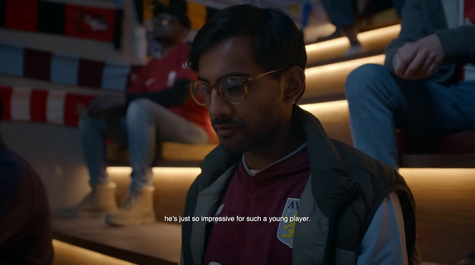 a man with glasses sitting on a set of stairs