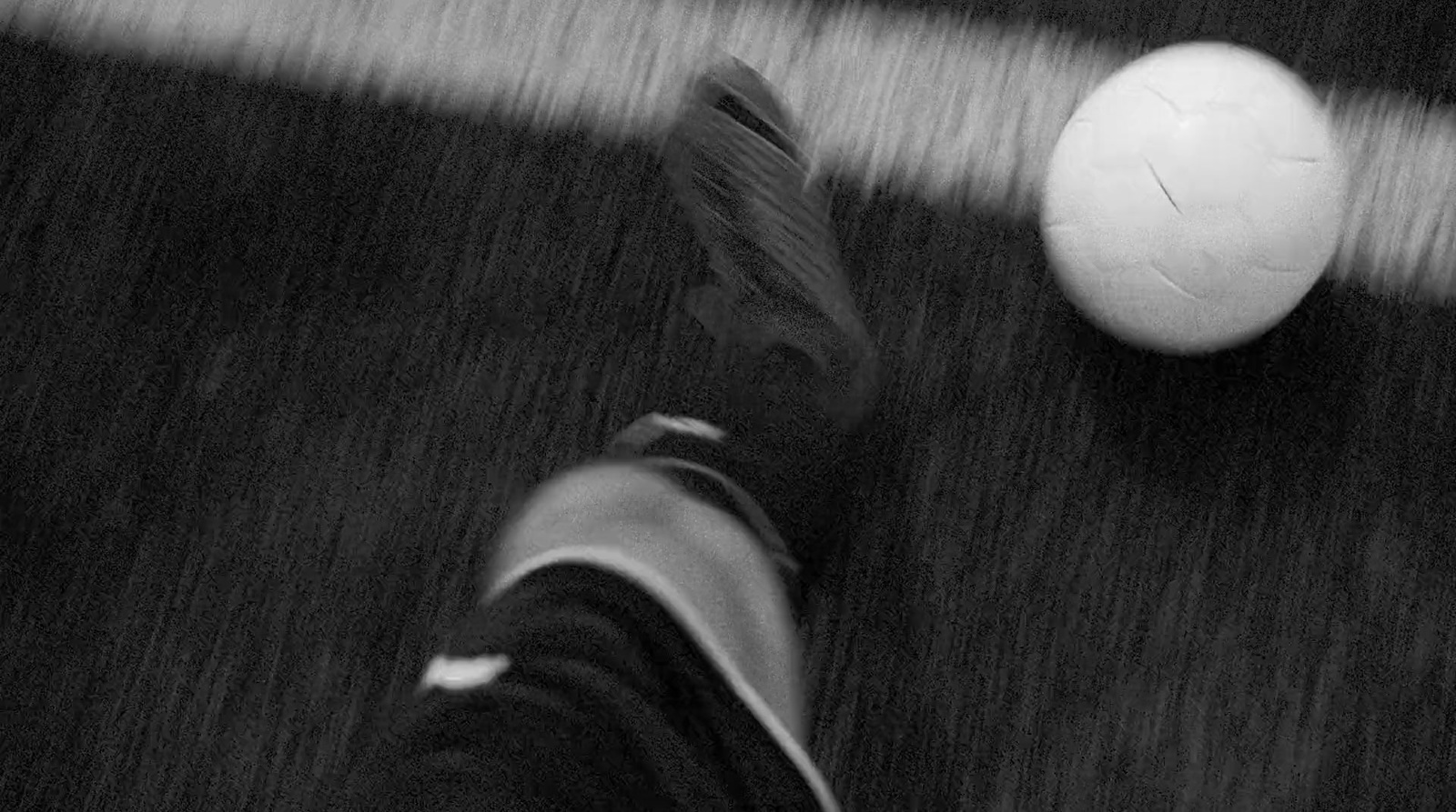 a black and white photo of a person's feet next to a soccer ball