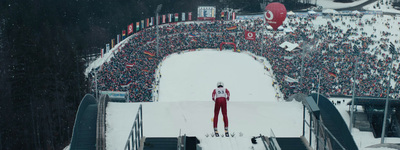 a skier stands at the top of a snowy slope