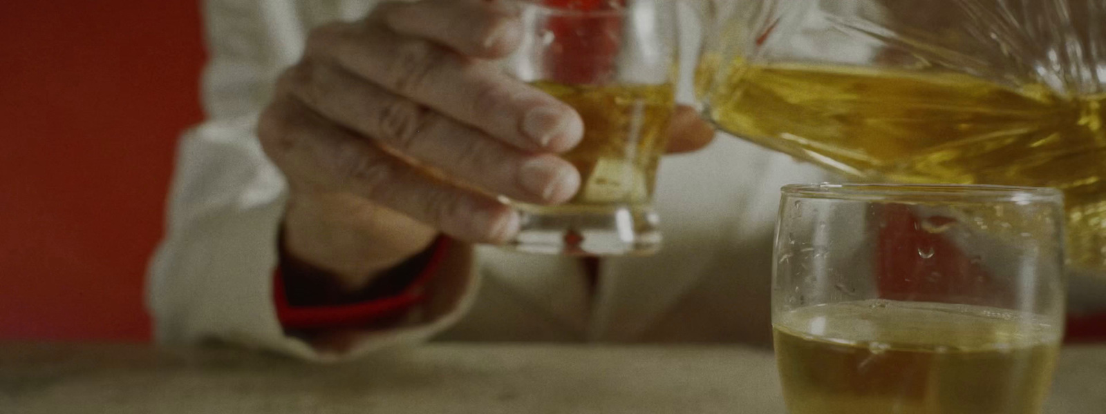 a person pouring a drink into a glass