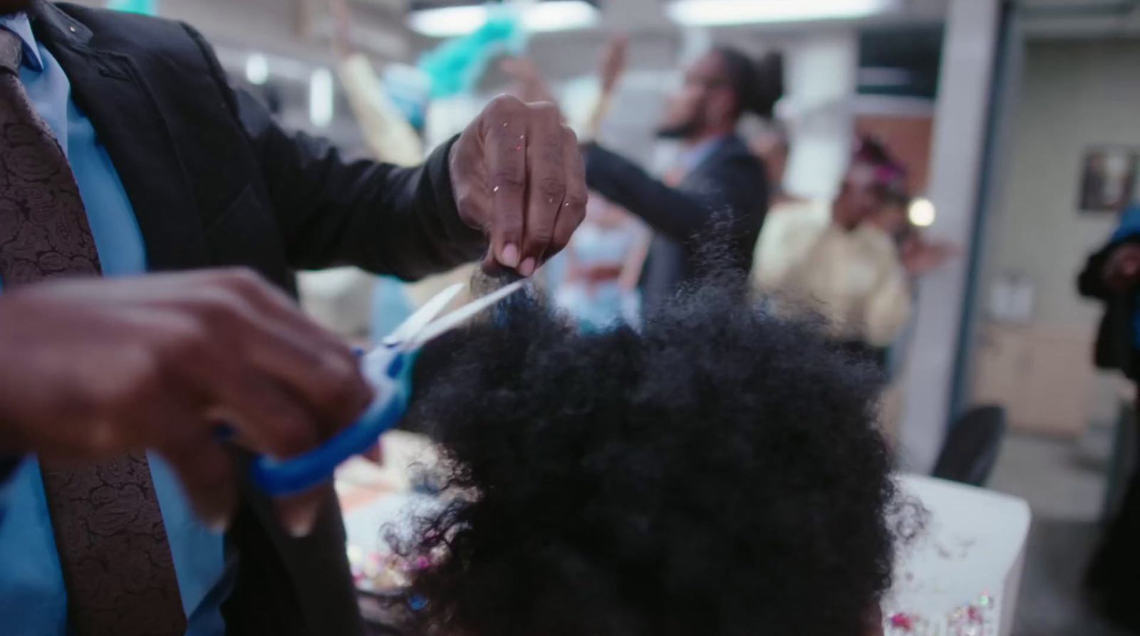 a man cutting another mans hair with scissors