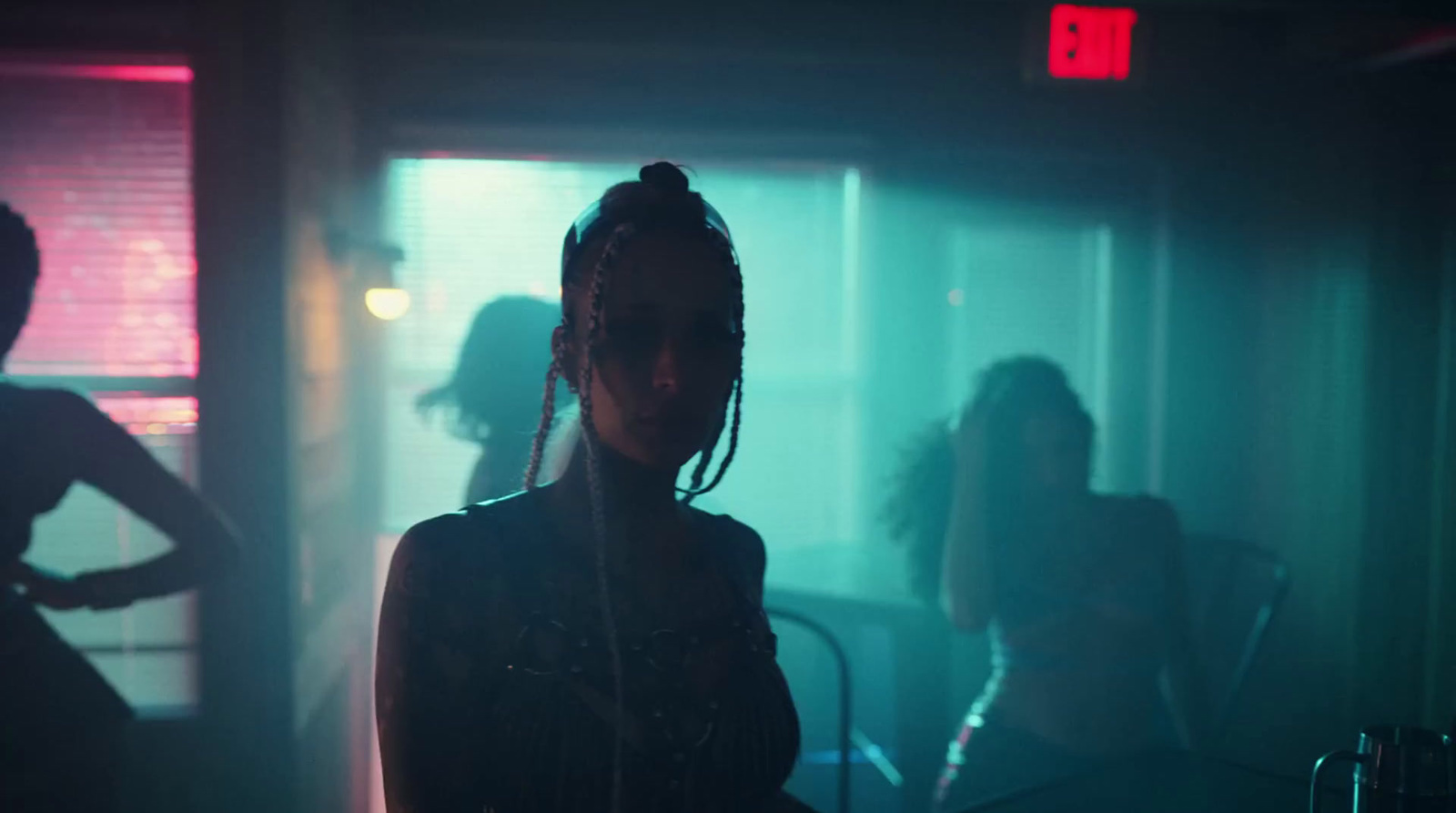 a woman standing in front of a window in a dark room