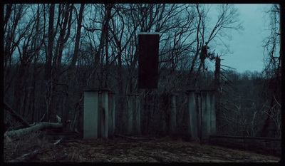 a fence in the middle of a forest at night