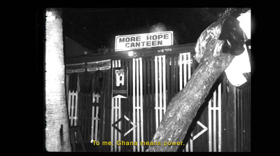 a black and white photo of a sign on a fence