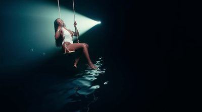 a woman sitting on a swing in the dark