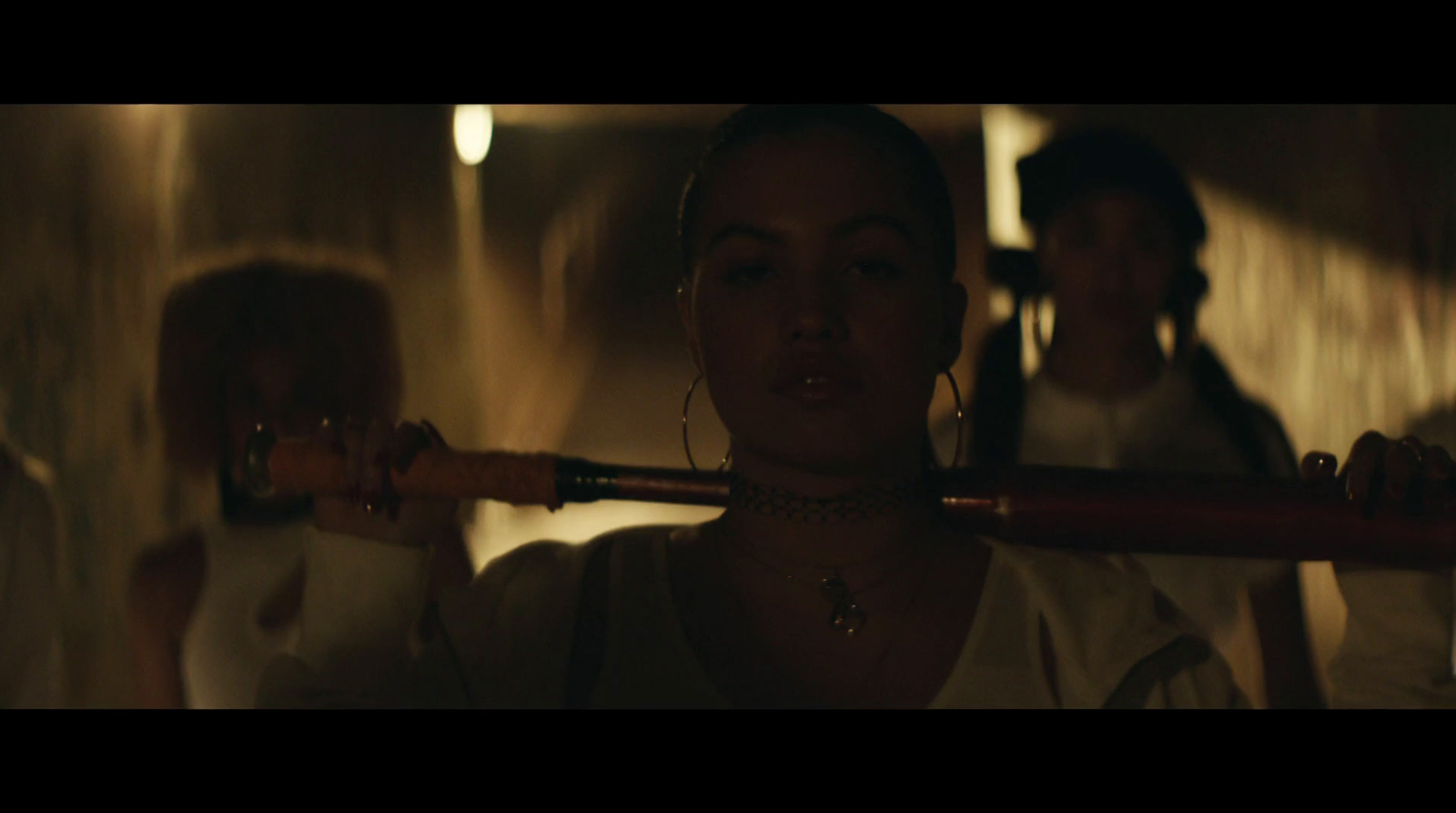 a woman holding a baseball bat in a dimly lit room