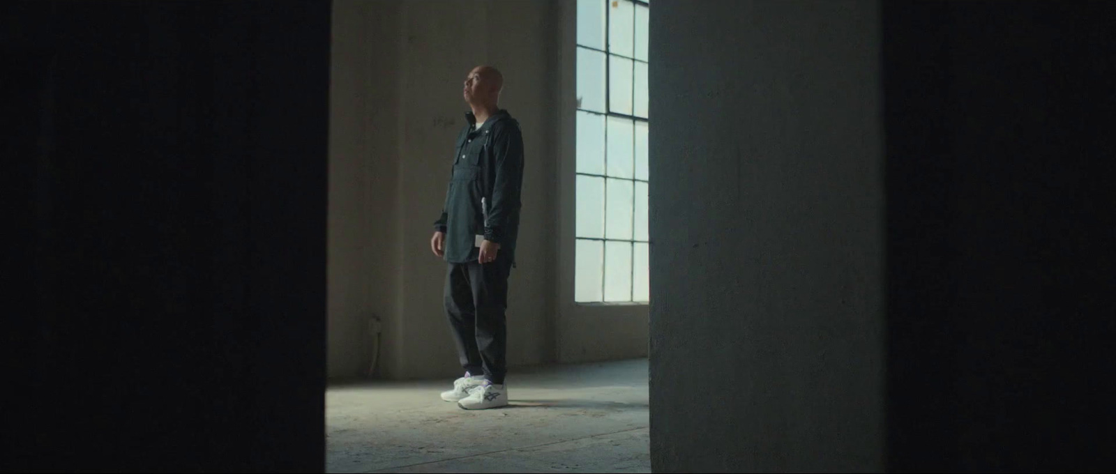 a man standing in a dark room looking up