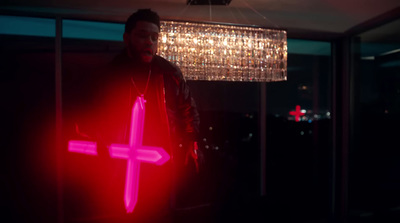 a man holding a red cross in a dark room