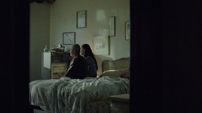 a couple of women sitting on top of a bed