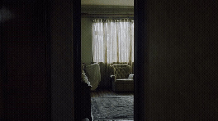 a doorway leading to a living room with a couch and chair