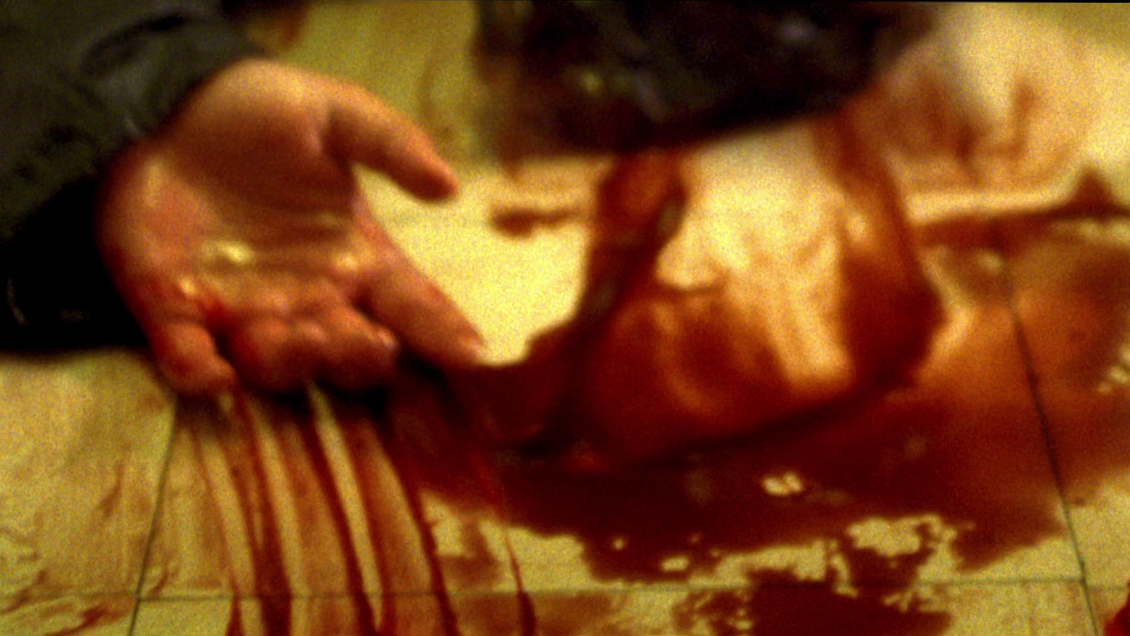 a person holding a knife and fork with blood on the floor