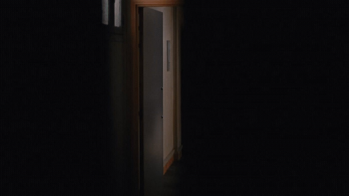 an open door in a dark room with a clock on it