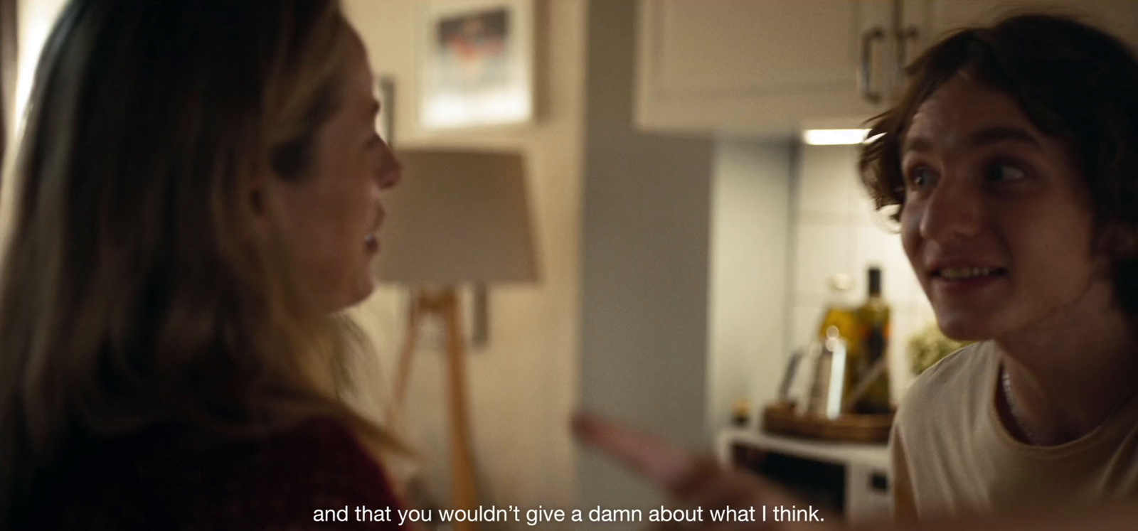 a woman talking to another woman in a kitchen