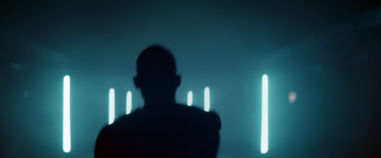 a person standing in front of a wall with neon lights