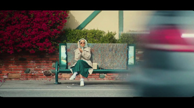 a woman is sitting on a green bench