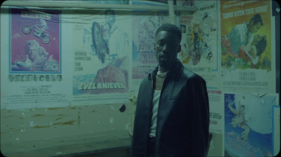 a man standing in front of a wall covered in posters