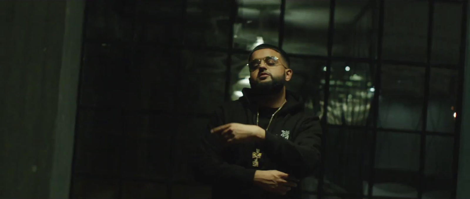 a man standing in front of a window in a dark room