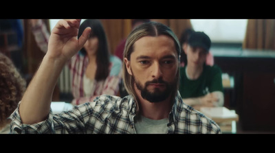 a man with long hair and a goatee is standing in front of a group