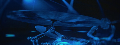 a man playing drums in a dark room