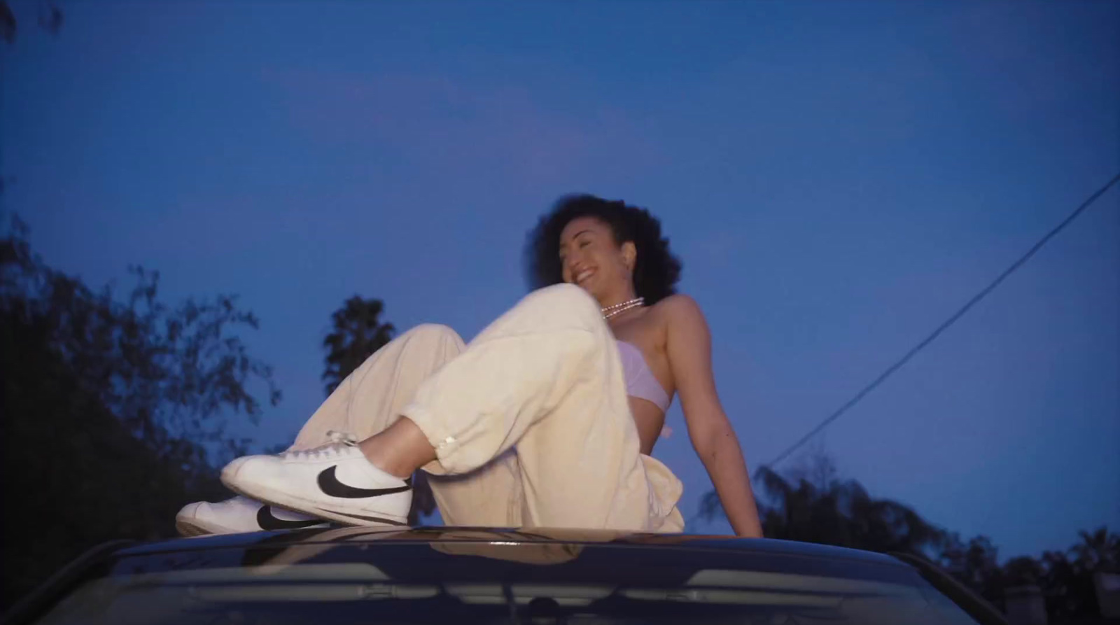 a woman sitting on the hood of a car