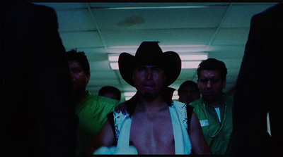 a man wearing a cowboy hat standing next to other men