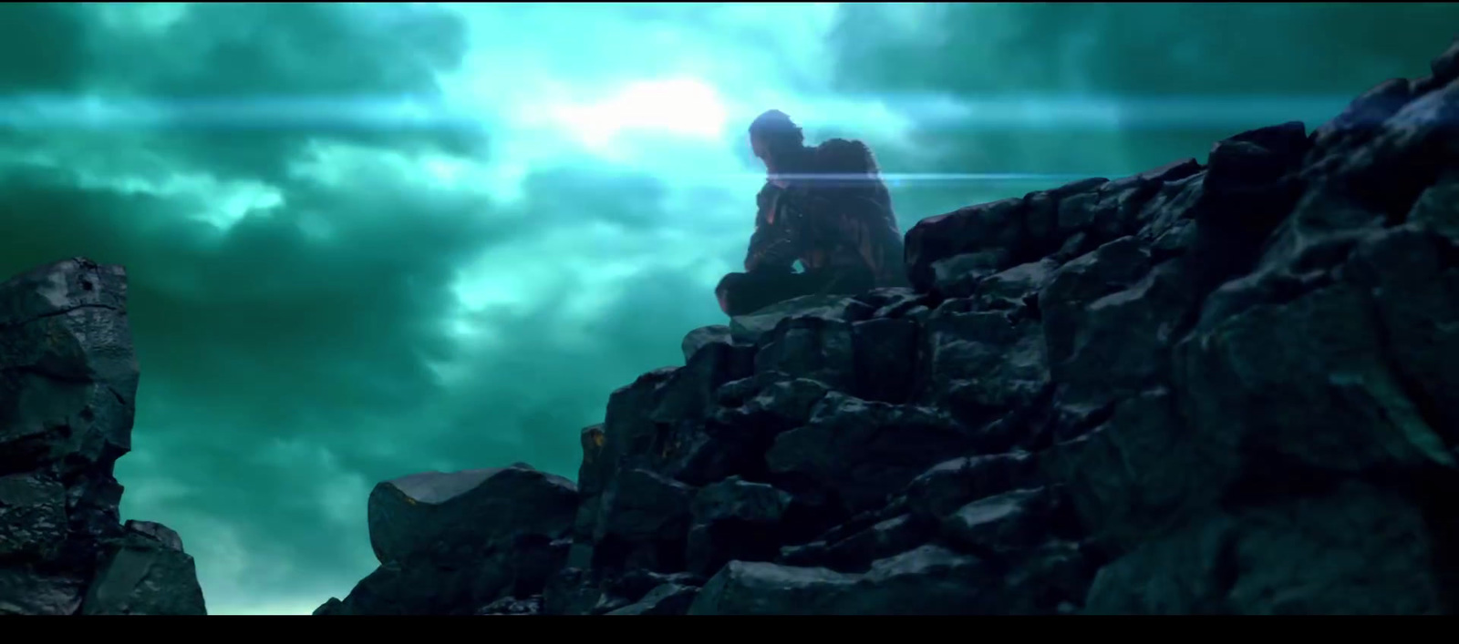 a man standing on top of a rocky mountain under a cloudy sky